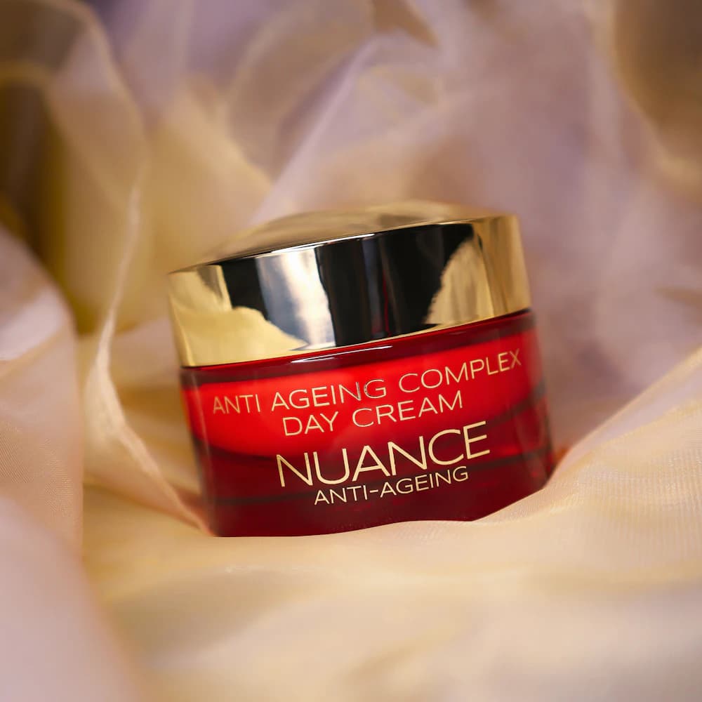 A face cream jar resting on softly draped fabric